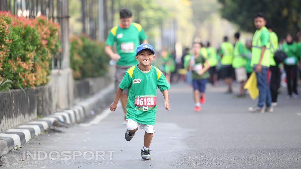 Salah seorang pelari cilik dengan ekspresi gembira  mengikuti kategori 1,6K.